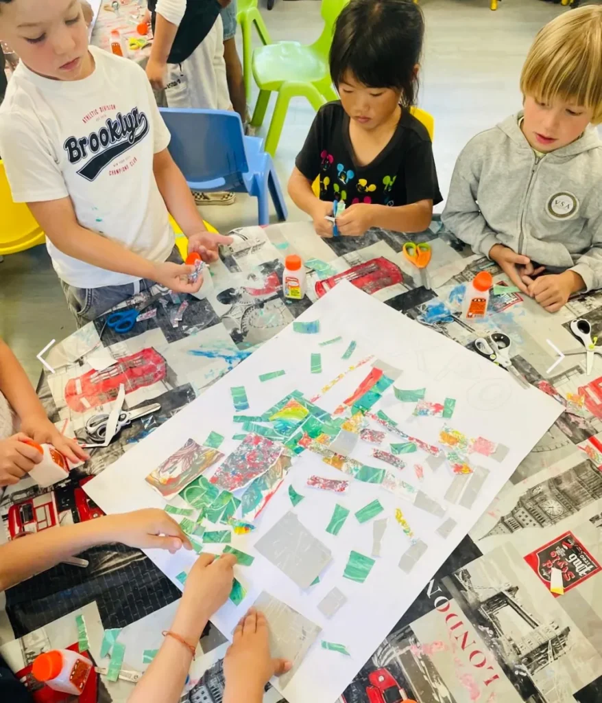 Élèves réalisant un collage collectif en atelier d’arts plastiques à l’École Val Saint André, Aix-en-Provence