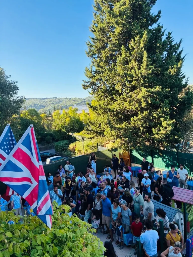 Vue sur le parc arboré de l’École Val Saint André avec les drapeaux britannique et américain de l’école bilingue