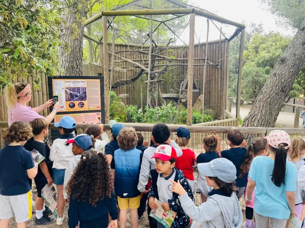 Élèves de l’École Val Saint André en sortie scolaire devant une volière dans un parc animalier